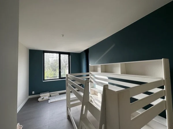 Kinderkamer met donkergroene accentwand en stapelbed